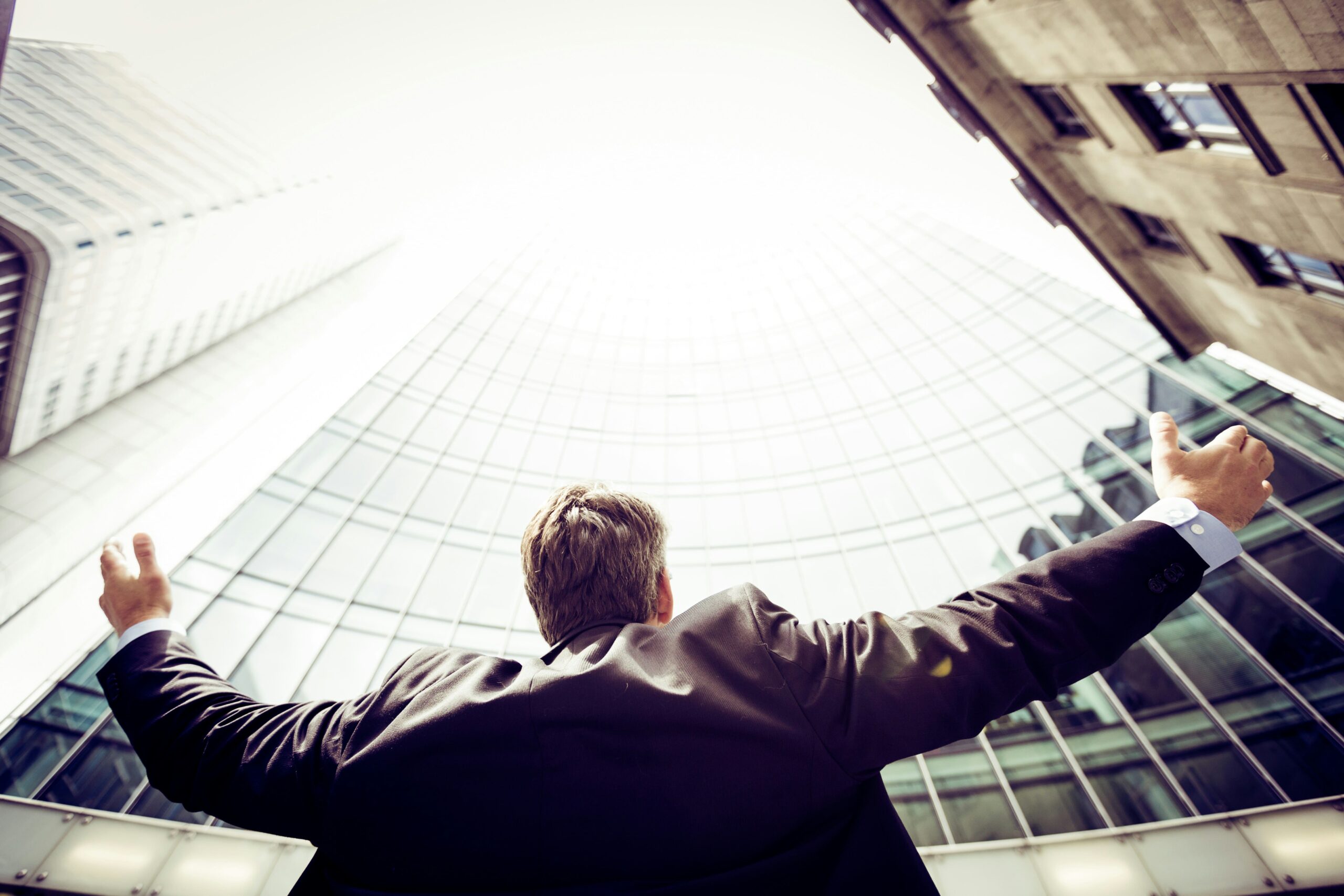 Man looking up at a tall building.